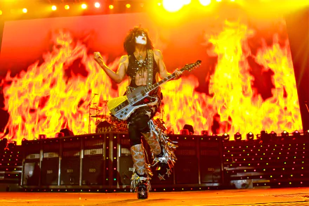 HD PC desktop wallpaper: KISS (Band) rock performer in signature face paint and armor playing guitar amid towering stage flames.