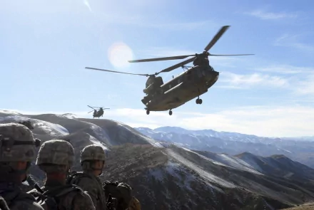 Military Boeing CH-47 Chinook helicopter flies above snowy mountains with 101st Airborne soldiers in the foreground, captured in this HD desktop wallpaper.