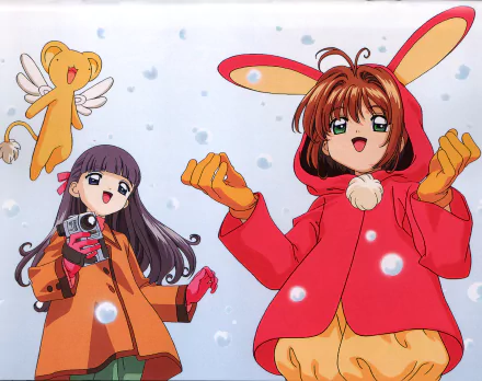HD anime PC desktop wallpaper of Cardcaptor Sakura: Sakura Kinomoto in a red bunny-hood coat and Tomoyo Daidouji filming, with Keroberos floating amid falling snow.