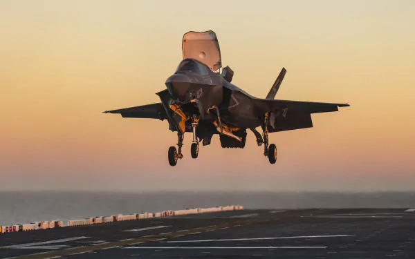 Lockheed Martin F-35 Lightning II jet fighter warplane landing on an aircraft carrier at sunset, captured in high-definition for a desktop wallpaper backdrop.