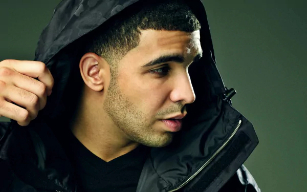 High-definition desktop wallpaper featuring a profile view of a man in a black hooded jacket against a muted background.