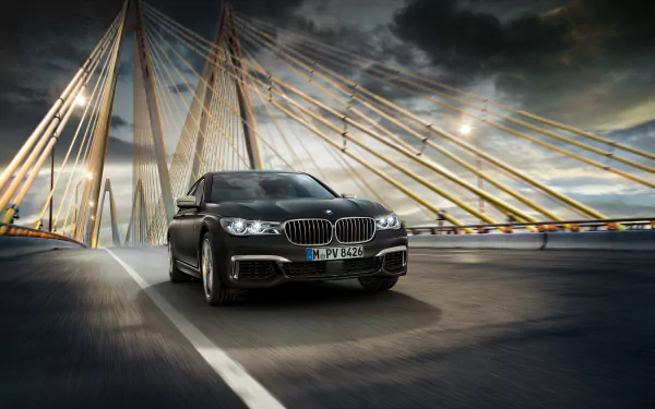 Black BMW 7 Series car driving on a bridge under a dramatic cloudy sky, captured in high-definition for a PC desktop wallpaper background.