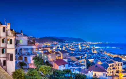Vibrant night view of the Amalfi Coast in Italy, showcasing colorful houses and city lights along the coastline in stunning 4K Ultra HD quality.