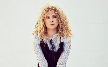 HD desktop wallpaper featuring English actress Juno Temple with blonde curly hair against a light background.