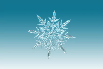 Artistic close-up of a detailed snowflake against a gradient blue background, rendered in 4K Ultra HD for a crisp PC desktop wallpaper.