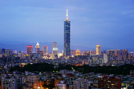 HD desktop wallpaper of Taipei, Taiwan cityscape at dusk, skyline of buildings with the prominent man-made skyscraper Taipei 101 glowing above the city.