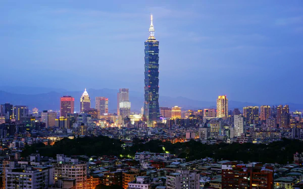 HD desktop wallpaper of Taipei, Taiwan cityscape at dusk, skyline of buildings with the prominent man-made skyscraper Taipei 101 glowing above the city.