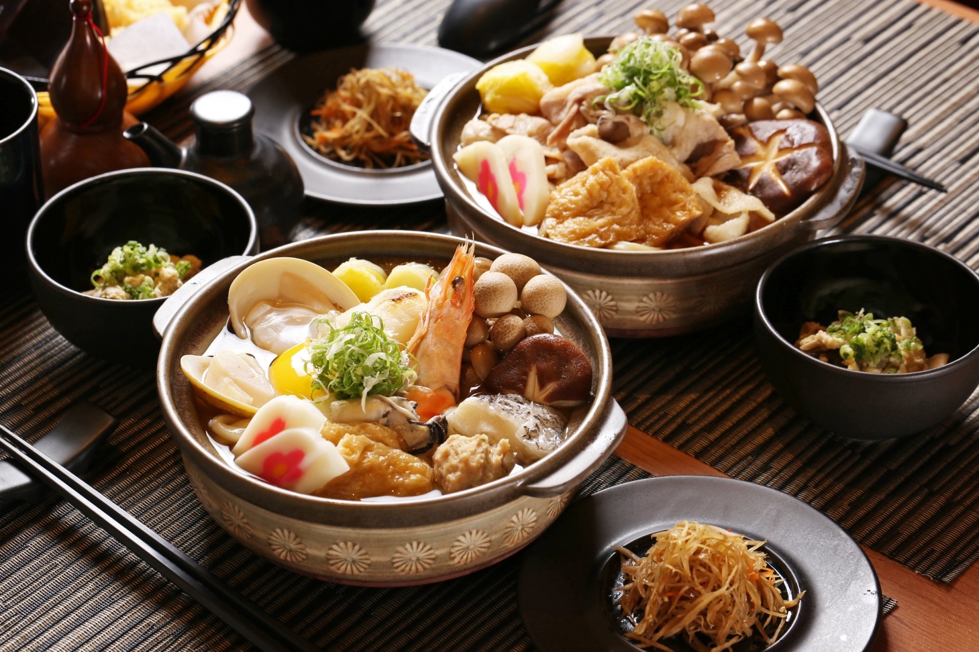 A vibrant HD desktop wallpaper featuring a traditional Japanese meal with bowls of seafood, shrimp, mushrooms, and various garnishes on a wooden table setting.