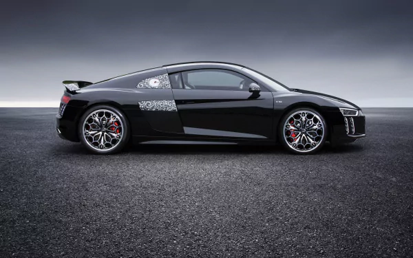 HD desktop wallpaper of a sleek black Audi R8 V10 captured from a side profile, positioned on an asphalt surface under a cloudy sky.