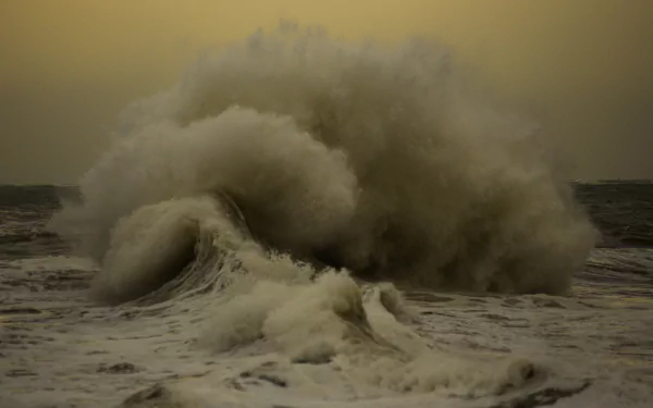 HD PC desktop wallpaper of nature: Ocean Waves crashing into a towering foamy curl under a moody, dusky sky.