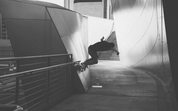 Black and white HD desktop wallpaper showing a skateboarder performing a wall ride trick in an urban sports setting.