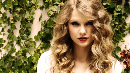 High-definition desktop wallpaper of a person with blonde curly hair and red lipstick in front of green foliage.