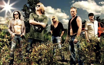 HD PC wallpaper of a five-member hard rock/heavy metal band in a sunlit field, leather-and-denim attire, dramatic clouds and backlighting — music band portrait background.