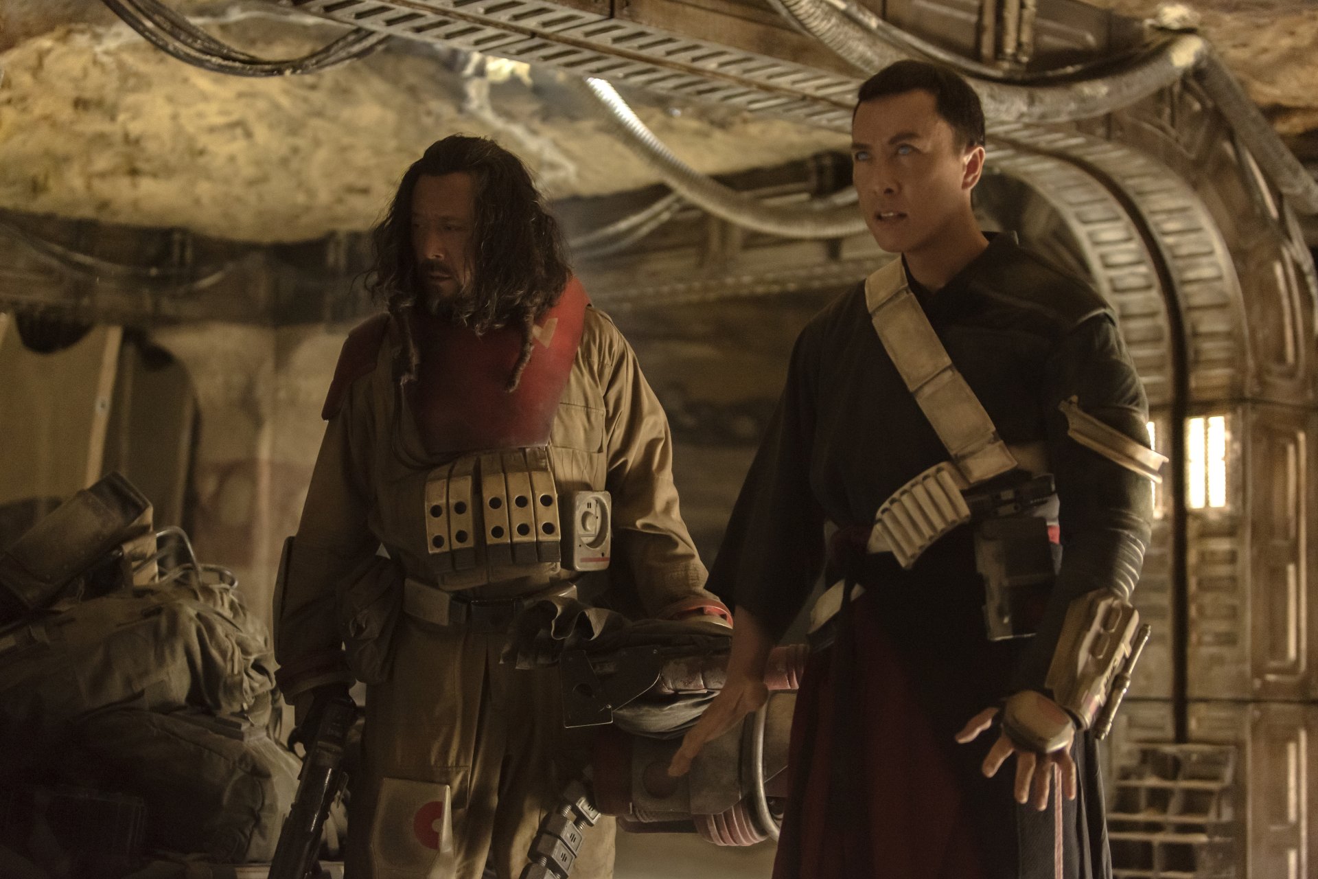 HD desktop wallpaper featuring Baze Malbus (Wen Jiang) and Chirrut Îmwe (Donnie Yen) from the movie Rogue One: A Star Wars Story, set in a rugged, industrial interior.