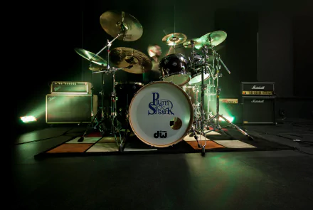 HD desktop wallpaper of a drum set including cymbals and multiple drums, set up in a music studio with amplifiers in the background.