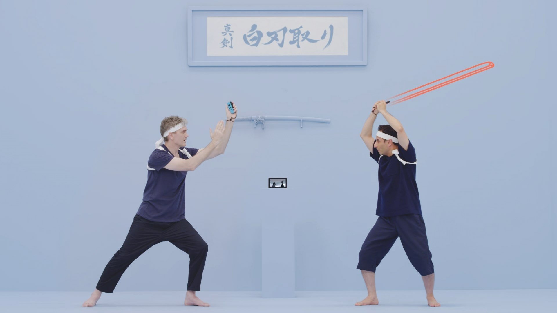 HD desktop wallpaper for 1-2-Switch featuring two people in a mock sword fight stance against a blue backdrop with Japanese text overhead.