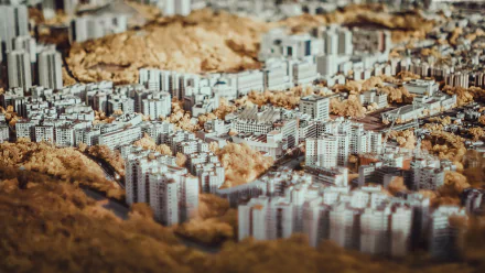 Tilt-shift HD PC desktop wallpaper of Hong Kong, China: dense high-rise cityscape photographed in miniature-style with warm golden tones.