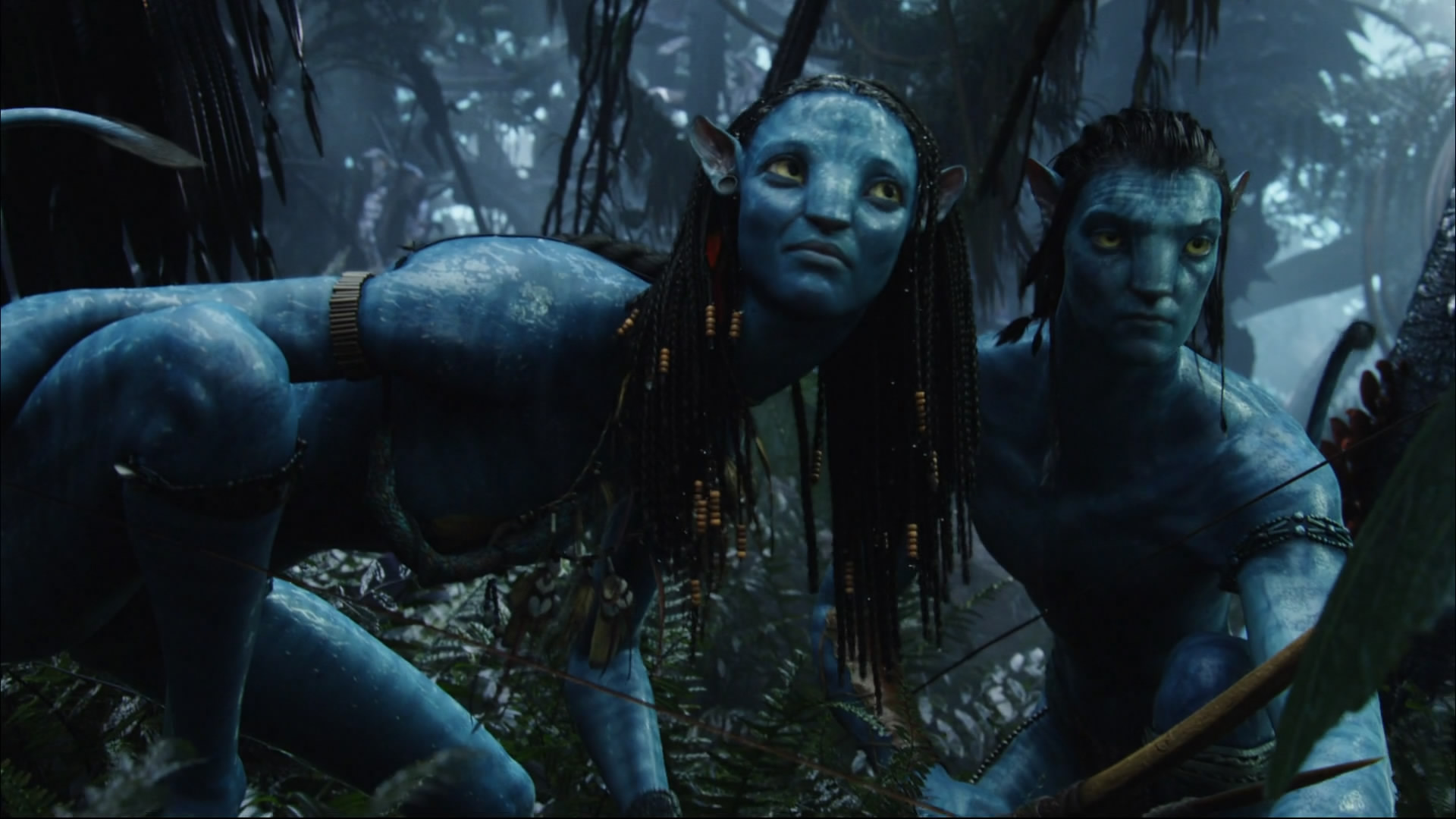 Avatar characters Neytiri and Jake Sully with long hair, yellow eyes, and weapons, in a natural setting.
