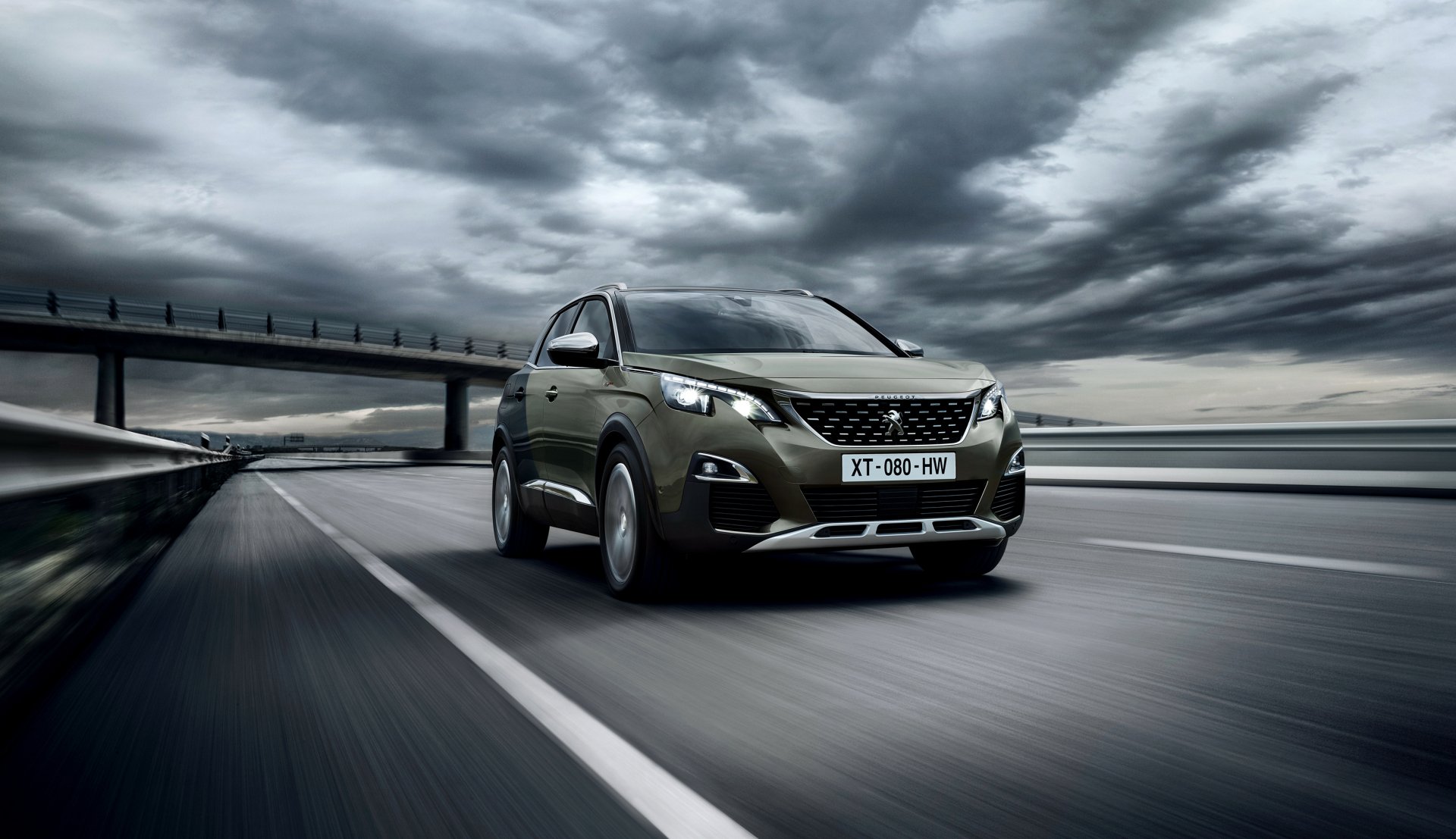 HD desktop wallpaper of a Peugeot 3008 SUV driving on a highway under a dramatic cloudy sky, showcasing the sleek design of this vehicle.