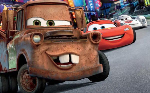 HD PC desktop wallpaper from the movie Cars 2: rusty Tow Mater grins in the foreground with Lightning McQueen and rivals racing past neon-lit city streets.