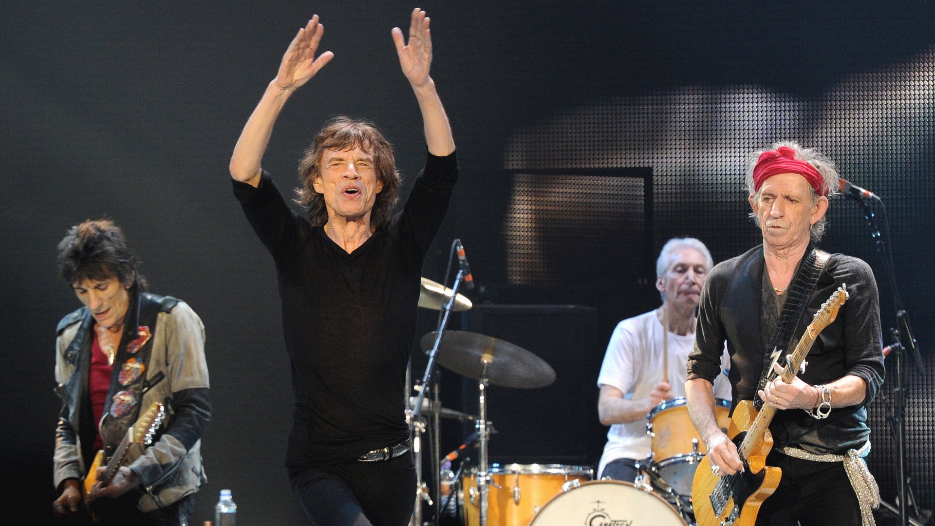 HD desktop wallpaper featuring The Rolling Stones performing live on stage, capturing the energy of the iconic rock band during a music concert.