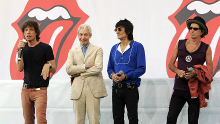 HD desktop wallpaper featuring The Rolling Stones band members standing in front of the iconic red tongue logo, representing classic rock music.