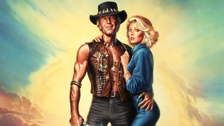 HD desktop wallpaper featuring iconic characters from the movie Crocodile Dundee, showcasing a rugged man in a leather vest and a blonde woman against a vivid sky background.