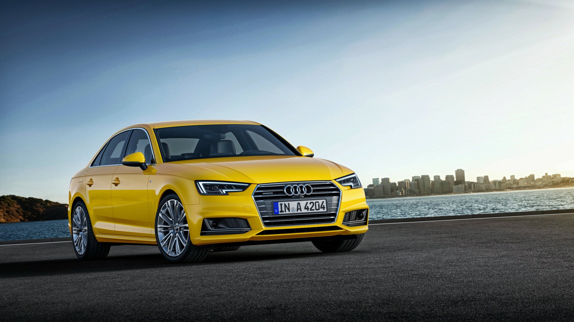 Yellow Audi A4 vehicle parked along a waterfront under a clear sky — 2K Quad HD PC desktop wallpaper and background.