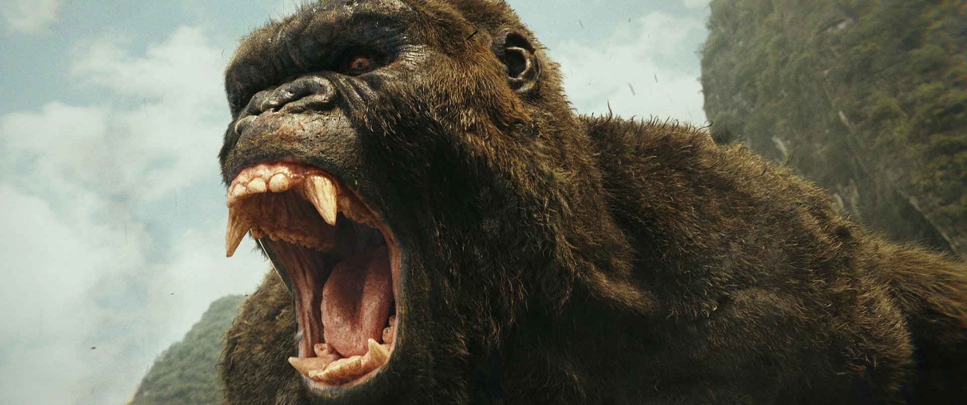 A high-definition desktop wallpaper featuring a roaring Kong from the movie Kong: Skull Island, set against a natural, rugged backdrop.