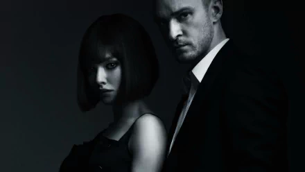 HD PC desktop wallpaper: moody movie-poster style image for In Time showing a serious man in a suit and a woman with a short dark bob, posed side by side in dramatic low-key lighting.