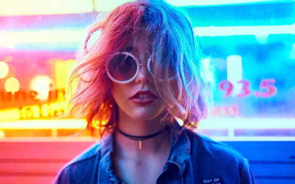 HD desktop wallpaper featuring a blonde woman with short hair, wearing sunglasses and lipstick, illuminated by vibrant neon lights.