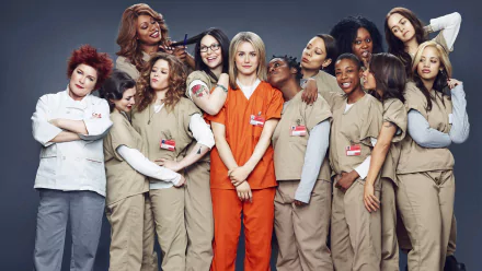 A high-definition wallpaper featuring the cast of Orange Is the New Black, with the characters posing together in prison uniforms against a simple background.