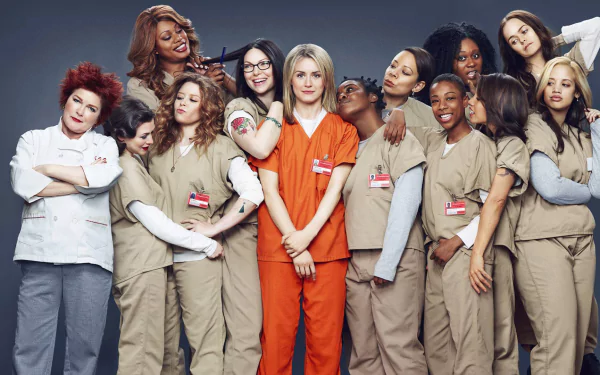 A high-definition wallpaper featuring the cast of Orange Is the New Black, with the characters posing together in prison uniforms against a simple background.