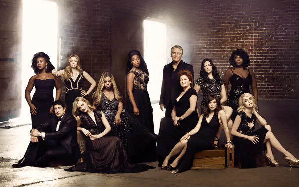 HD desktop wallpaper featuring the cast of the TV show Orange Is the New Black. The cast members are dressed in elegant black attire, posed against a dimly lit, industrial-style backdrop.