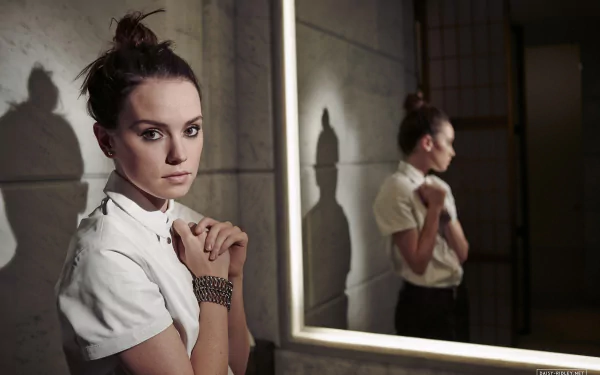 Brunette actress Daisy Ridley poses thoughtfully by a mirror, captured in this HD PC desktop wallpaper and background.