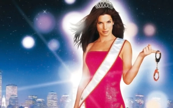 HD desktop wallpaper of a smiling woman in a tiara and sash wearing a pink gown, holding a pair of handcuffs against a glowing city skyline — movie-poster style.