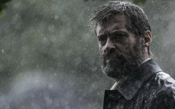 HD desktop wallpaper featuring Hugh Jackman as Wolverine in the movie Logan, standing in the rain with a determined expression.