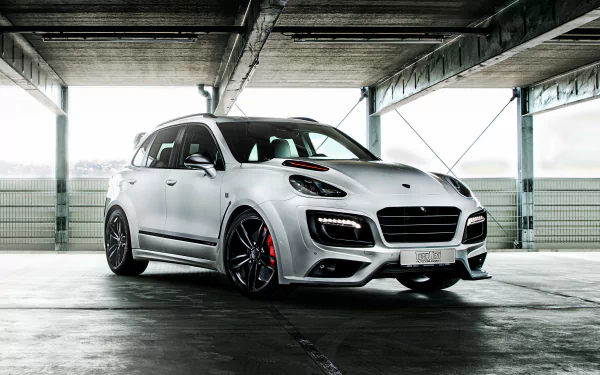 White Porsche Cayenne SUV in a concrete parking garage with dramatic lighting — sleek white car rendered as a 2K Quad HD PC desktop wallpaper.