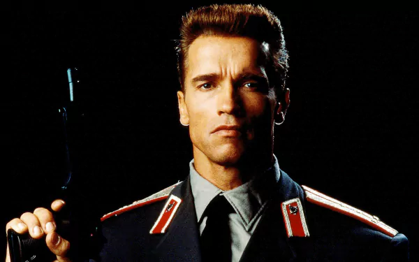 HD desktop wallpaper of Arnold Schwarzenegger in his Red Heat movie role, dressed in a dark uniform and holding a gun against a black background.