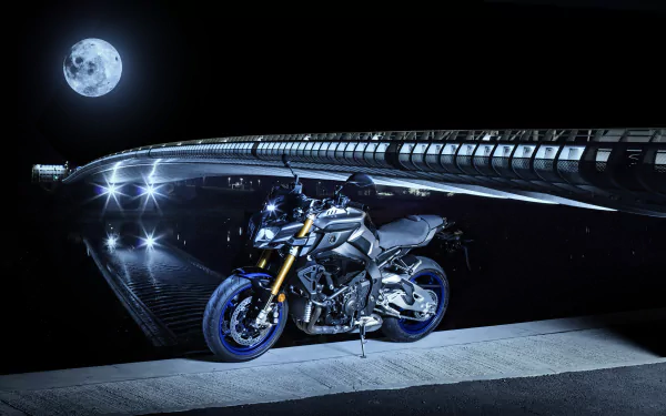 A Yamaha MT-10 motorcycle parked under a bridge at night with a full moon in the background, captured in stunning 4K Ultra HD quality.