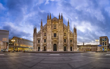 HD desktop wallpaper showcasing the intricate Gothic architecture of Milan Cathedral, a renowned religious landmark in Italy, under a dramatic evening sky.