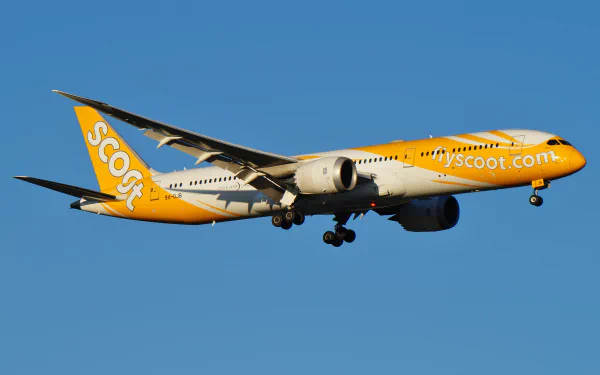 Boeing 787 Dreamliner aircraft in Scoot livery captured mid-flight against a clear blue sky, displayed as a 4K Ultra HD desktop wallpaper.