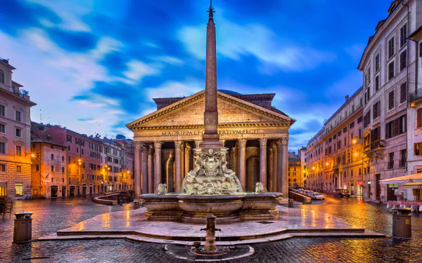 HD desktop wallpaper showcasing the iconic Pantheon with its obelisk and fountain in the heart of Rome, Italy, surrounded by historic city buildings under a vibrant sky.