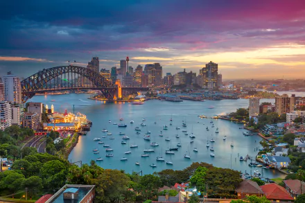 Lavender Bay at Sydney Harbour with the iconic Sydney Harbour Bridge, boats on the water, and the city skyline at sunset in Australia.