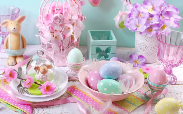 HD wallpaper displaying a pastel-colored Easter still life with decorated eggs, flowers, a bunny figurine, and festive holiday decorations.