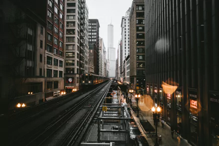 An HD desktop wallpaper featuring a tram railroad flanked by skyscrapers in the bustling city of Chicago, USA. The buildings and cityscape create an impressive urban scene.