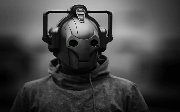 A high-definition desktop wallpaper featuring a Cyberman from the TV show Doctor Who (2005). The cyborg character stands against a blurred background, depicted in a monochromatic palette.