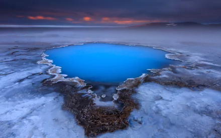 HD wallpaper of a serene Icelandic lake surrounded by ice, capturing the beauty of nature with vibrant blue water and a mystical atmosphere.
