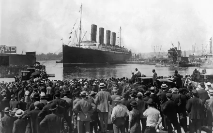 Black and white HD photograph of the Titanic departing, with a large crowd gathered at the dock. This image serves as a desktop wallpaper and background.