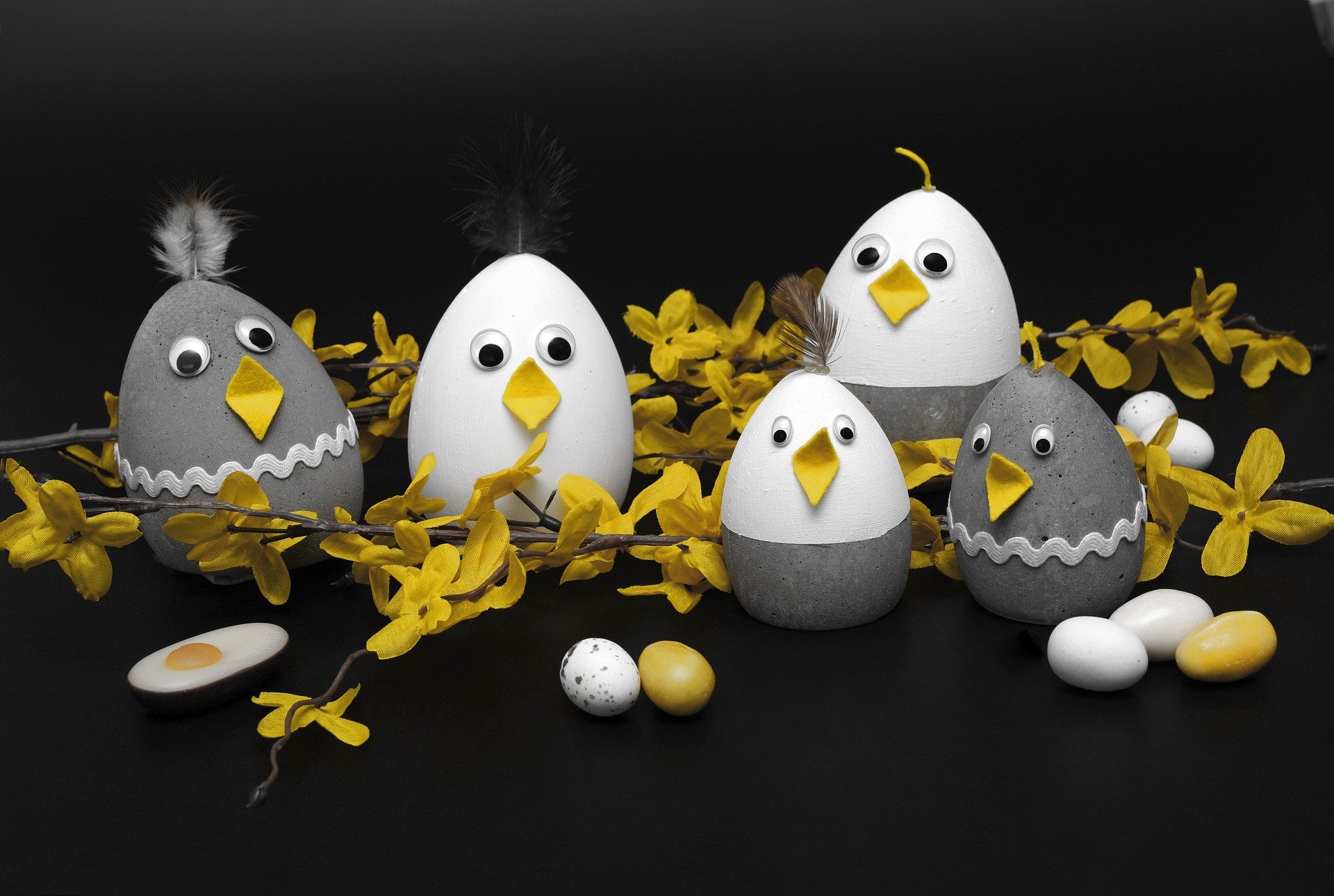 HD PC desktop wallpaper and background: playful Easter holiday scene of decorated egg chicks and yellow forsythia on a black backdrop.